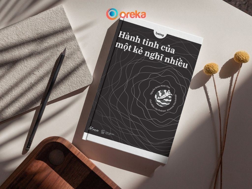 Review Sách Hành Tinh Của Một Kẻ Nghĩ Nhiều Chi Tiết 2 sách Hành tinh của một kẻ nghĩ nhiều. Hình ảnh cuốn sách được đặ trên bàn, bên cạnh có một cây bút, 1/4 cuốn sổ và khay gỗ, và 2 cành hoa khô.